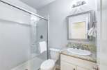 This modern bathroom features a sleek glass-enclosed shower and a stylish vanity with a granite countertop.
