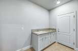 This laundry room features a spacious granite countertop with an undermount sink, perfect for all your washing needs.
