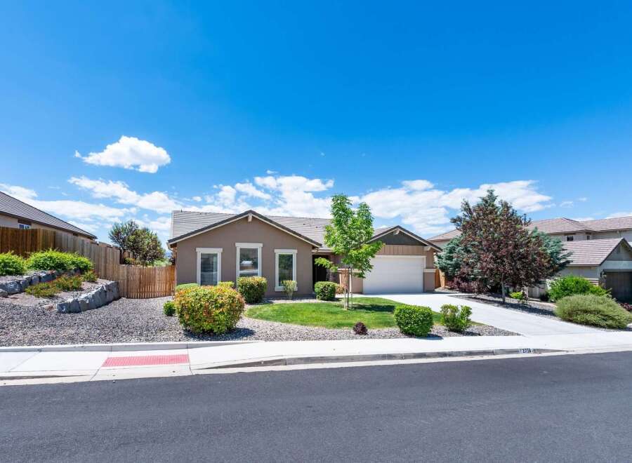 Discover this charming single-story home featuring a welcoming facade and a well-maintained front yard with lush greenery and mature trees.