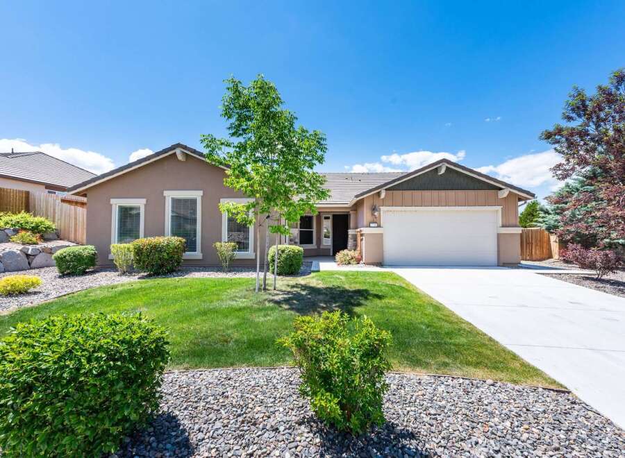 Discover this charming single-story home featuring a welcoming facade and a well-maintained front yard with lush green grass and decorative rock landscaping.