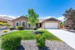 Discover this charming single-story home featuring a welcoming facade and a well-maintained front yard with lush green grass and decorative rock landscaping.