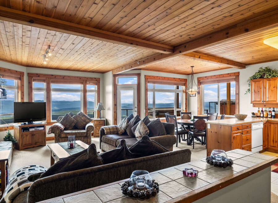 Experience breathtaking mountain views from this stunning living room, featuring a cozy fireplace and ample seating for relaxation.