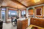 Experience breathtaking mountain views from this charming dining and kitchen area, featuring a cozy round dining table and a well-equipped kitchen with ample wooden cabinetry.