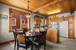 Enjoy cozy meals in this charming dining area, featuring a rich wood-toned round table with four dark leather chairs.