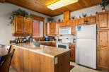 This charming kitchen features warm, knotty pine cabinetry and a spacious breakfast bar perfect for casual dining.
