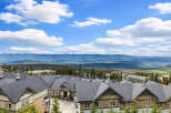 Discover this stunning mountain retreat featuring modern townhomes with dark pitched roofs and warm-toned exteriors.