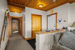 Step into a warm and inviting entryway featuring a charming wooden ceiling and a convenient ski rack, perfect for mountain enthusiasts.