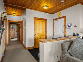 Step into a warm and inviting entryway featuring a charming wooden ceiling and a convenient ski rack, perfect for mountain enthusiasts.