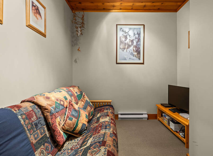 Cozy living space featuring a comfortable sofa with a vibrant, patterned comforter and throw pillows.