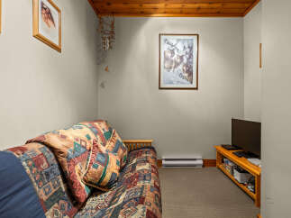 Cozy living space featuring a comfortable sofa with a vibrant, patterned comforter and throw pillows.