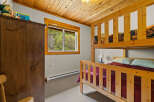 This charming bedroom features a cozy bunk bed and a large wooden wardrobe, perfect for families or groups.