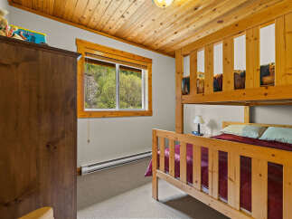 This charming bedroom features a cozy bunk bed and a large wooden wardrobe, perfect for families or groups.