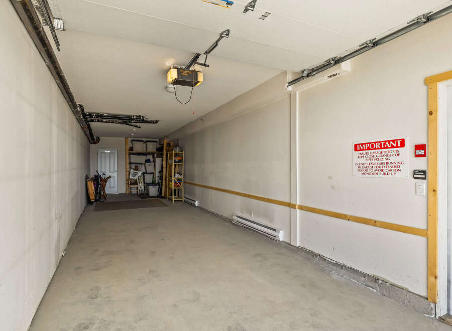 This spacious garage offers ample storage solutions with shelving units and overhead storage.