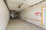 This spacious garage offers ample storage solutions with shelving units and overhead storage.