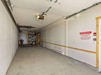 This spacious garage offers ample storage solutions with shelving units and overhead storage.