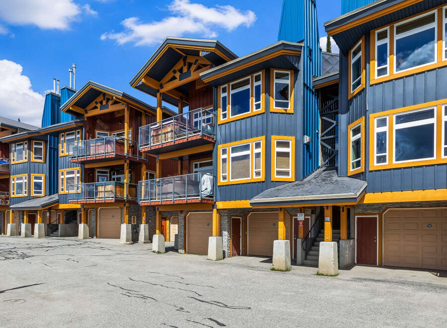 Discover modern mountain living in this stunning multi-level property featuring a striking blue and wood exterior.