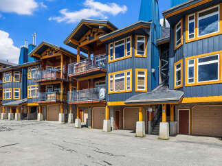 Discover modern mountain living in this stunning multi-level property featuring a striking blue and wood exterior.