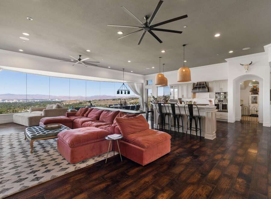 Experience breathtaking panoramic views from this stunning open-concept living space, featuring a plush sectional sofa perfect for relaxation.