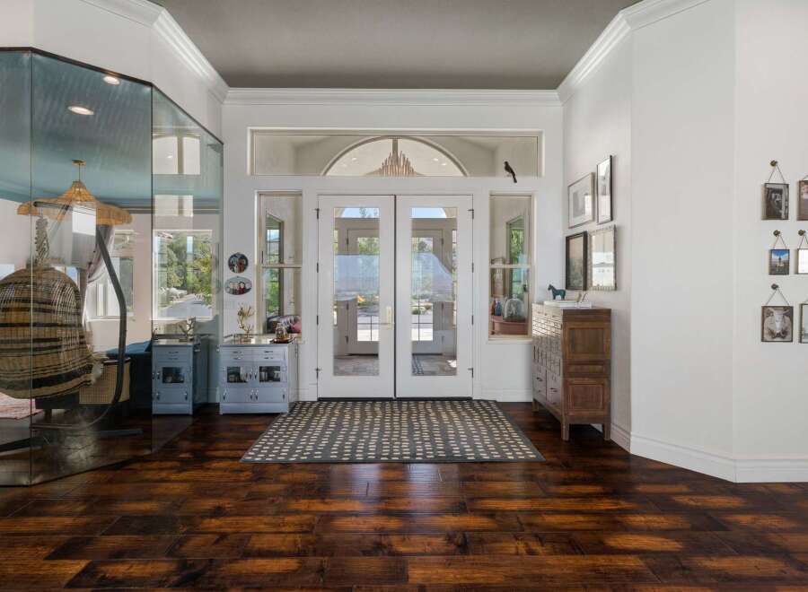 Step into a grand entryway featuring elegant double doors that open to a sunlit interior.