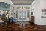 Step into a grand entryway featuring elegant double doors that open to a sunlit interior.
