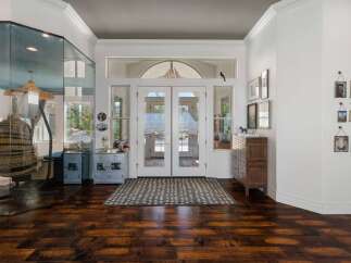 Step into a grand entryway featuring elegant double doors that open to a sunlit interior.