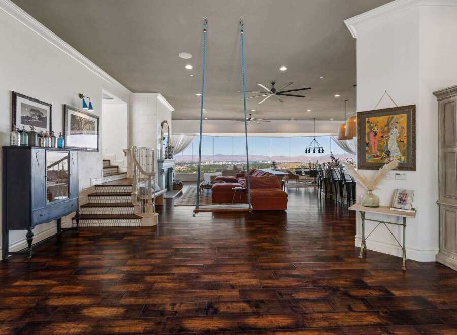 Experience breathtaking panoramic views from this stunning living space, featuring a unique indoor swing and a cozy fireplace.