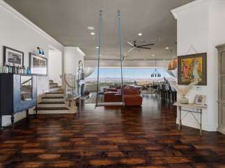 Experience breathtaking panoramic views from this stunning living space, featuring a unique indoor swing and a cozy fireplace.
