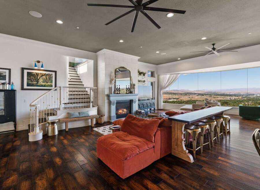 Experience breathtaking panoramic views from this stunning living space, featuring a cozy fireplace and a large sectional sofa perfect for entertaining.