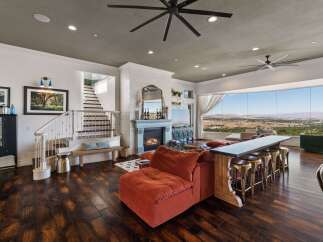 Experience breathtaking panoramic views from this stunning living space, featuring a cozy fireplace and a large sectional sofa perfect for entertaining.