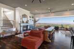 Experience breathtaking panoramic views from this stunning living room, featuring a modern sectional sofa and a sleek bar area perfect for entertaining.