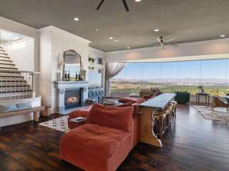 Experience breathtaking panoramic views from this stunning living room, featuring a modern sectional sofa and a sleek bar area perfect for entertaining.