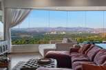 Experience breathtaking panoramic views of the city and mountains from this stunning living room.
