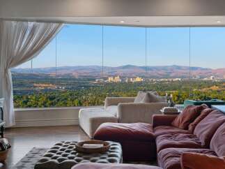Experience breathtaking panoramic views of the city and mountains from this stunning living room.