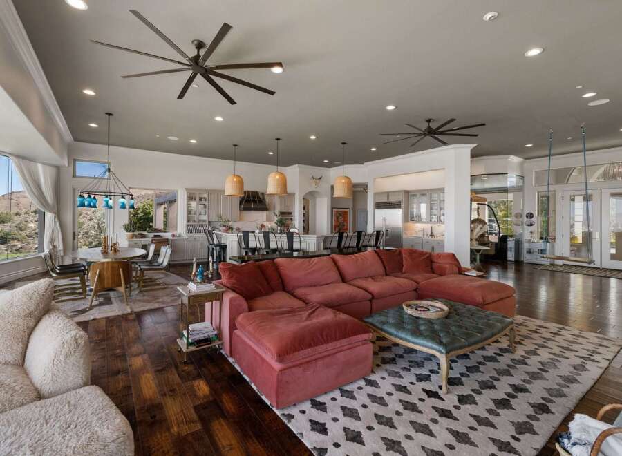 Experience luxurious open-concept living with this stunning great room, featuring a spacious sectional sofa and a large ottoman perfect for entertaining.