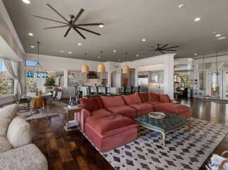 Experience luxurious open-concept living with this stunning great room, featuring a spacious sectional sofa and a large ottoman perfect for entertaining.