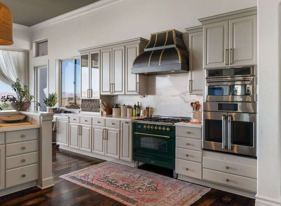 Experience culinary excellence in this stunning kitchen, featuring a professional-grade emerald green range complemented by a striking custom range hood.
