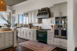 Experience culinary excellence in this stunning kitchen, featuring a professional-grade emerald green range complemented by a striking custom range hood.