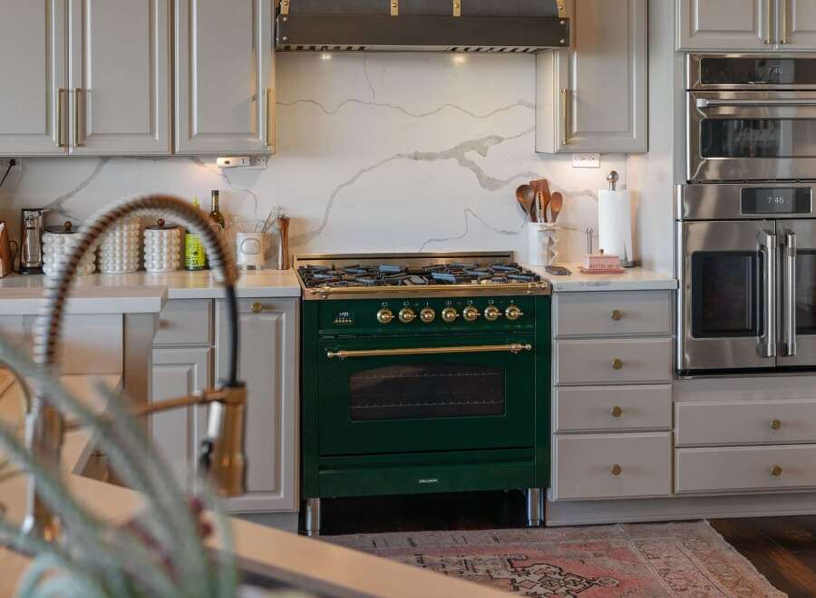 Experience culinary excellence in this stunning kitchen, featuring a professional-grade emerald green range with brass accents.