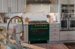 Experience culinary excellence in this stunning kitchen, featuring a professional-grade emerald green range with brass accents.
