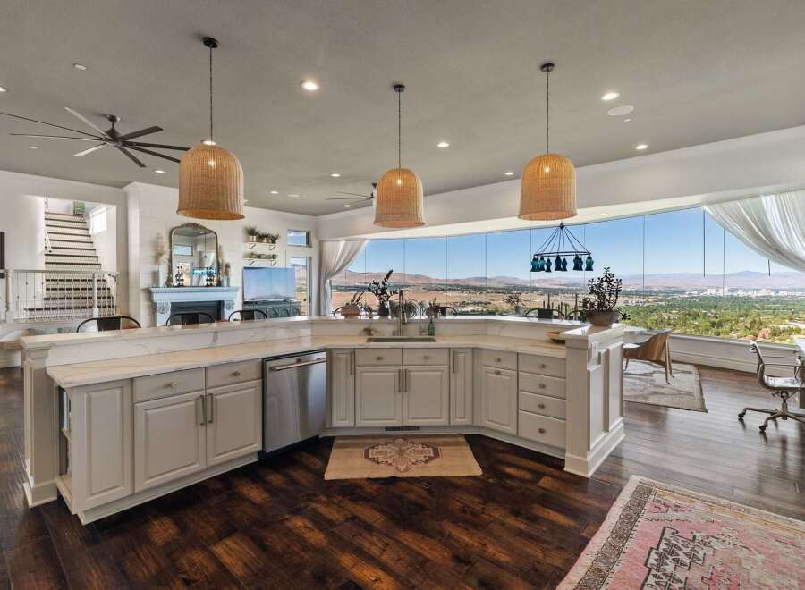 Experience breathtaking panoramic views from this stunning kitchen, featuring a large island with ample counter space and a sleek dishwasher.
