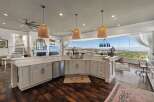 Experience breathtaking panoramic views from this stunning kitchen, featuring a large island with ample counter space and a sleek dishwasher.