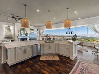 Experience breathtaking panoramic views from this stunning kitchen, featuring a large island with ample counter space and a sleek dishwasher.