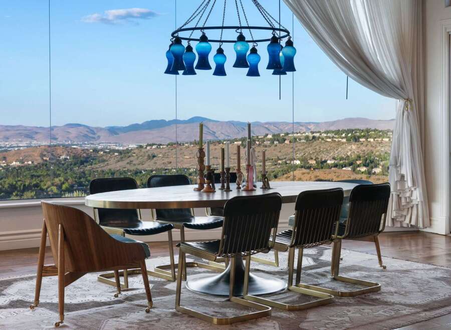 Experience breathtaking panoramic views from this elegant dining room, featuring a large oval table and stylish chairs perfect for entertaining.