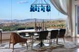 Experience breathtaking panoramic views from this elegant dining room, featuring a large oval table and stylish chairs perfect for entertaining.