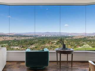 Experience breathtaking panoramic views from this stunning property, featuring expansive floor-to-ceiling windows that showcase a vibrant cityscape and rolling hills.