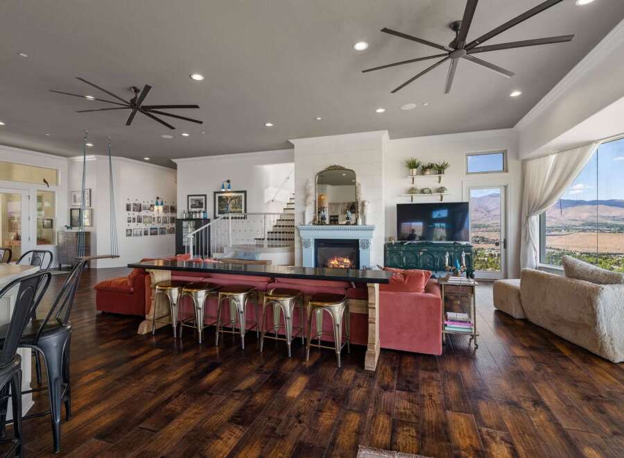 Experience luxurious open-concept living with a stunning fireplace and expansive windows offering breathtaking mountain views.