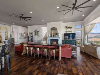 Experience luxurious open-concept living with a stunning fireplace and expansive windows offering breathtaking mountain views.