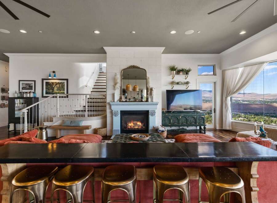 Experience luxury living in this stunning home featuring a modern open-concept living area with a cozy fireplace and a sleek bar perfect for entertaining.