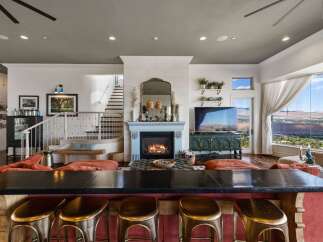 Experience luxury living in this stunning home featuring a modern open-concept living area with a cozy fireplace and a sleek bar perfect for entertaining.
