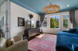 Experience luxurious living in this stunning room featuring a vibrant blue ceiling and a large, plush sectional sofa perfect for relaxation.